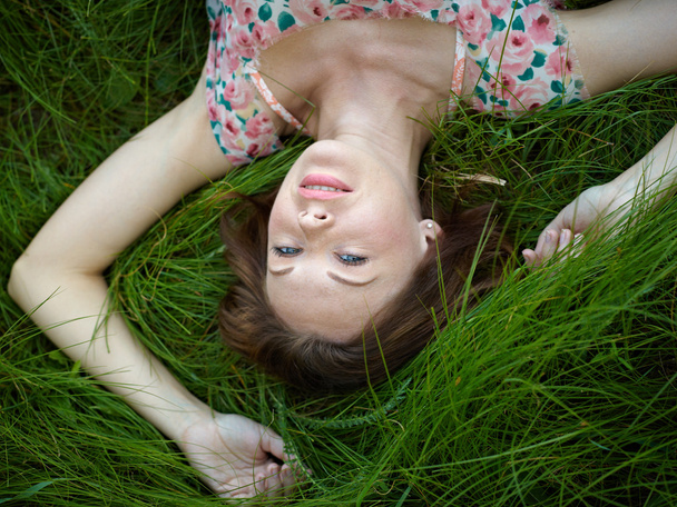 The woman lies in a grass - 写真・画像