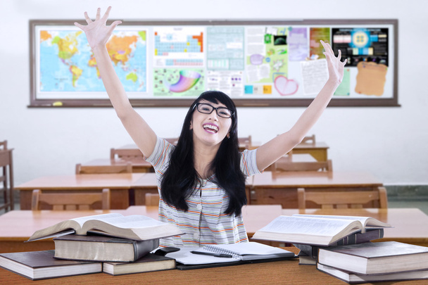 Cheerful student with books in class - 写真・画像