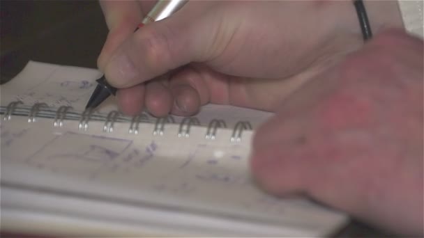 Die Hand des Mannes mit dem Stift machte Schallplatten im Notizbuch. - Filmmaterial, Video