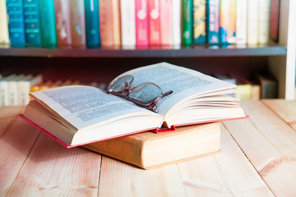 Brille und Buch auf Bücherregal - Foto, Bild