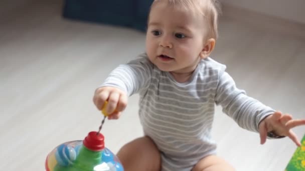 Sladké dítě hraje s barevnými hračkami doma - Záběry, video