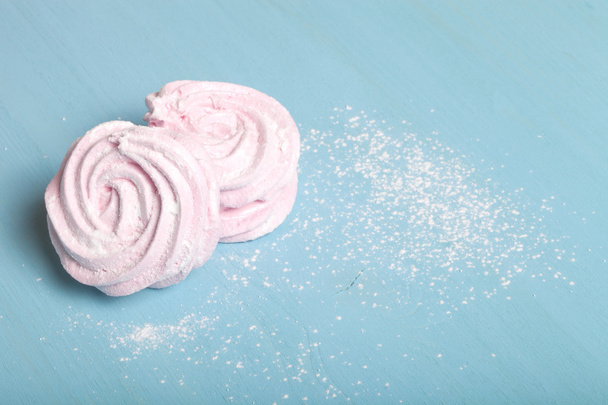 Fresh pink homemade zephyr - marshmallow on blue wooden table - Foto, afbeelding