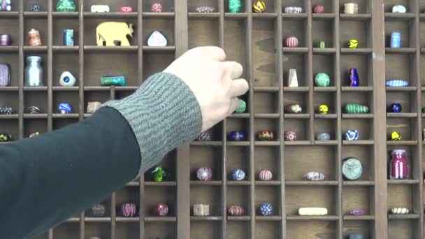 Homme plaçant divers objets décoratifs dans une étagère
 - Séquence, vidéo