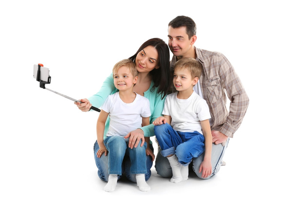 Happy family making selfie with selfie stick isolated on white - Zdjęcie, obraz