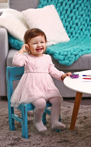 Little girl sitting on the chair in the room - Photo, Image