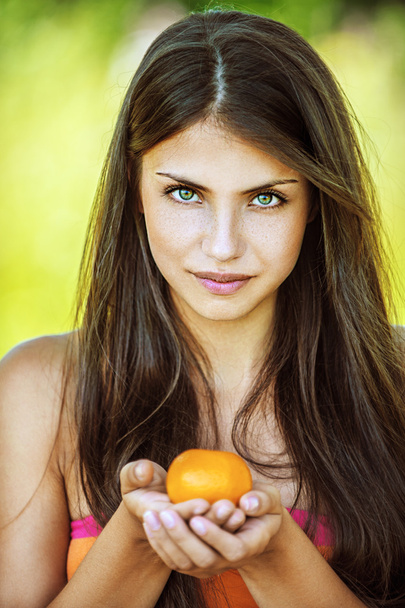 Beautiful woman holding tangerine - Fotoğraf, Görsel