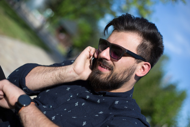 young handsome attractive bearded model man using smartphone in  - Foto, Imagen