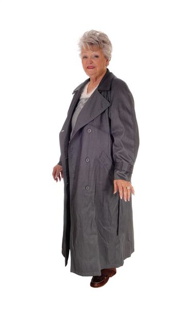 Senior woman standing in a long coat. - Foto, Imagen