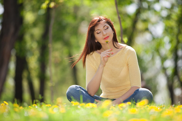 Young redhead woman in the park with flowers - Photo, image