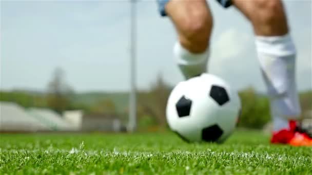 Αργή κίνηση των ποδιών του ποδοσφαιριστή ντρίμπλα μια μπάλα μπροστά από την κάμερα - Πλάνα, βίντεο