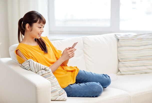 happy asian woman with smartphone at home - Photo, Image