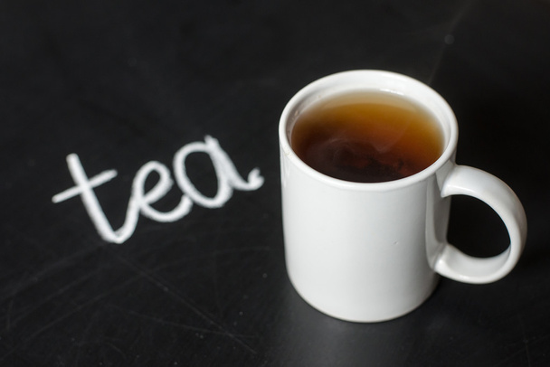taza de té caliente en una pizarra negra y texto
  - Foto, Imagen