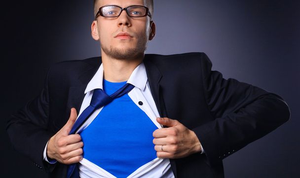 Молодий бізнесмен грає як супер герой і розриває сорочку, ізольовані на сірому фоні
 - Фото, зображення
