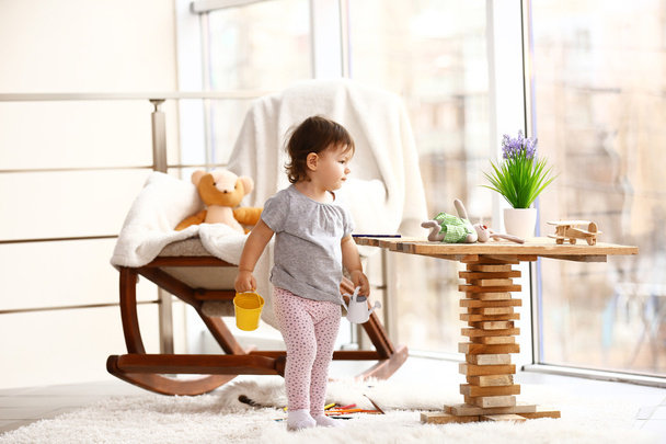 klein meisje spelen met speelgoed in de kamer - Foto, afbeelding