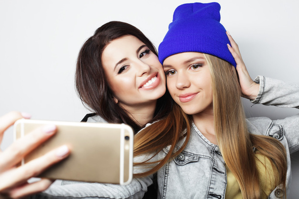 Two teenage girls friends in hipster outfit make selfie - Фото, зображення