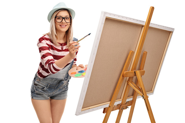 Young woman painting on a canvas  - 写真・画像