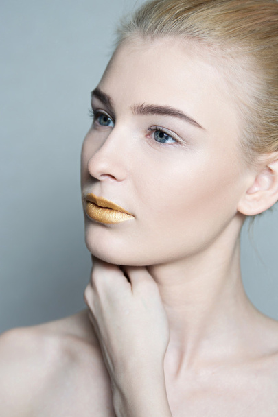 Closeup portrait of beautiful young woman with golden lips - Фото, изображение