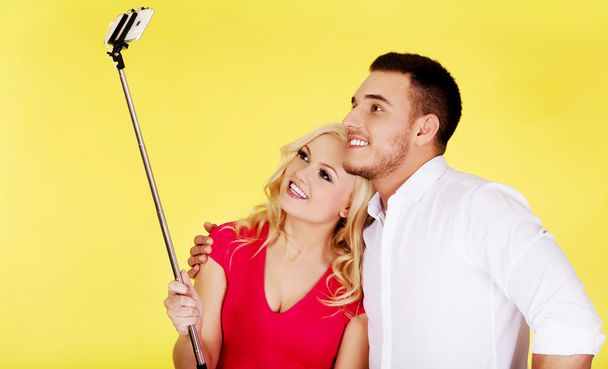 Happy couple taking selfie photo with selfie stick - Фото, изображение