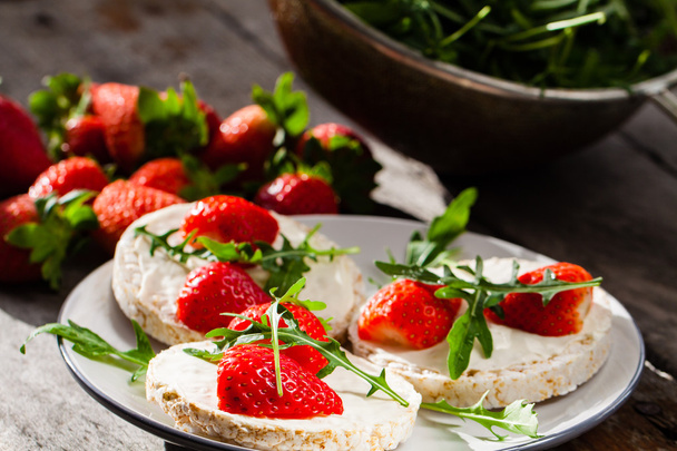Multigrain rice cakes with strawberries fruit, mascarpone cheese and arugula. - Photo, Image