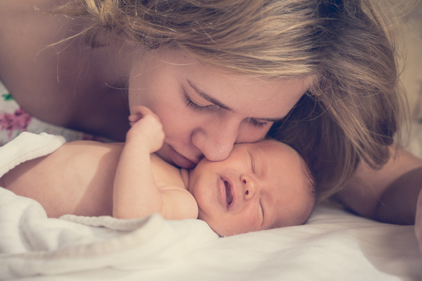 Mom gently kissisng newborn baby - Fotó, kép