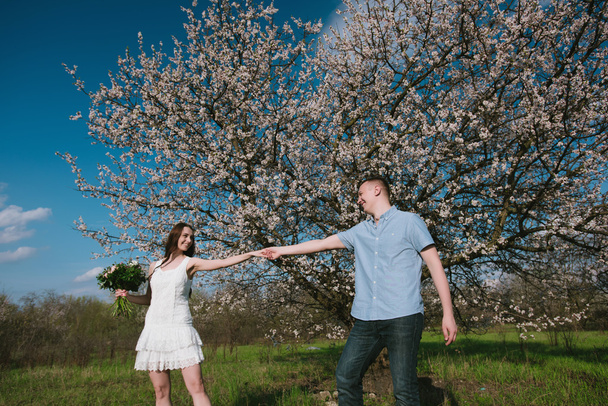 Beautiful young couple dancing and having fun on blue sky background - Fotó, kép