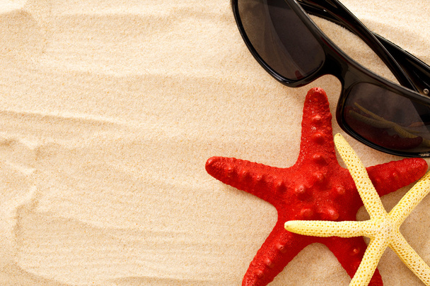 Étoiles de mer et lunettes de soleil sur le sable
 - Photo, image