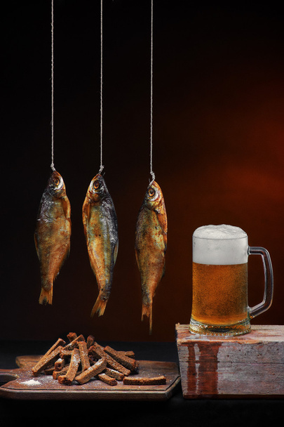 Mug of beer with smoked fish and salty crackers - Foto, imagen