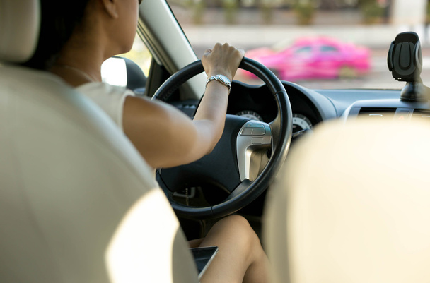 Femme avec téléphone portable sur ses genoux en conduisant
  - Photo, image