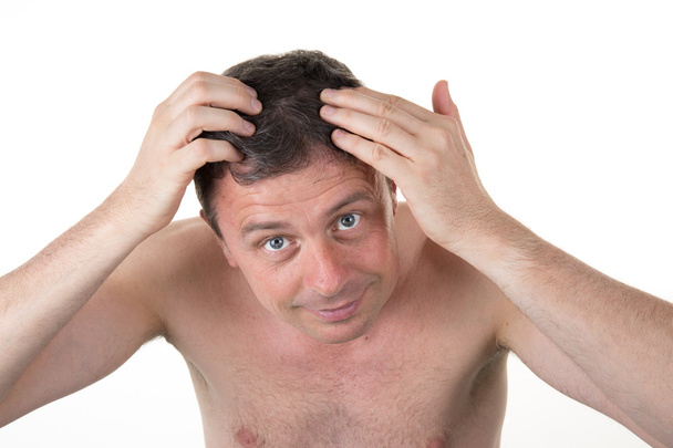 Homme devant miroir regardant ses cheveux isolés
 - Photo, image