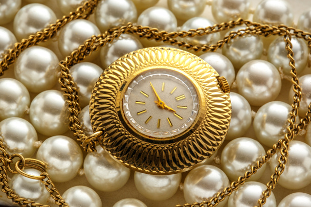 Χρυσό ρολόι σε closeup σχετικά με μαργαριτάρια - Φωτογραφία, εικόνα