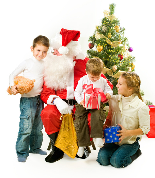 Santa Claus giving Christmas gifts to children - Foto, imagen