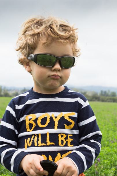 Three year old sulky boy in a farm field - Photo, Image