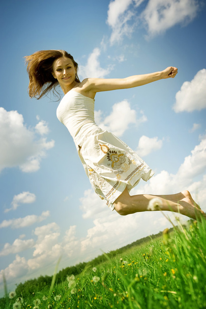 Happy Young Woman Jumping Over Blue Sky - Фото, зображення