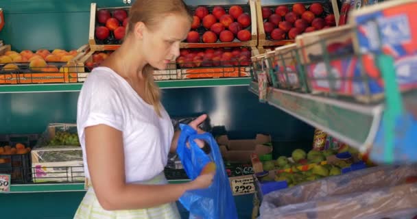 Mujer joven eligiendo peras en frutería
 - Imágenes, Vídeo