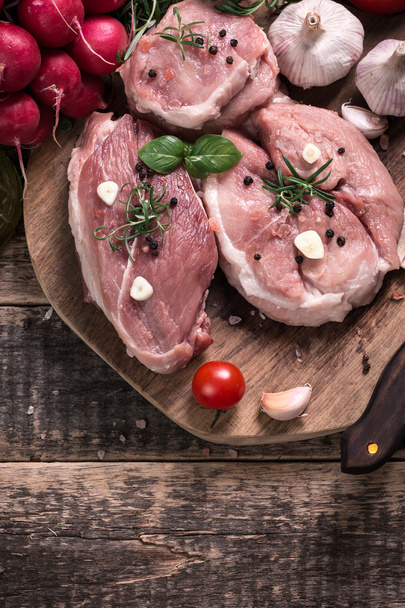 Čerstvý řezník nakrájíme maso sortimentu zdobené čerstvým rozmarýnem na dřevěný stůl - Fotografie, Obrázek