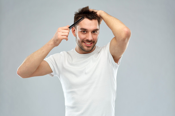 happy man brushing hair with comb over gray - Foto, imagen