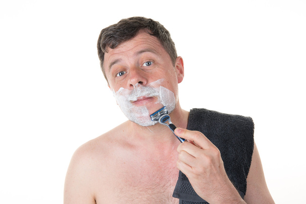 Man in his bathroom shaving in the morning - Photo, Image