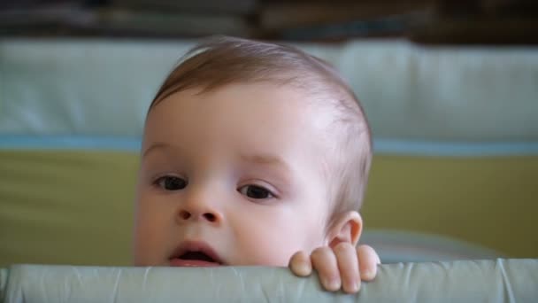 Yhdeksän kuukauden poika istuu leikkikehässä.
. - Materiaali, video