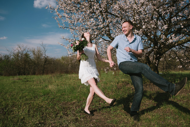 Hermosa pareja joven bailando y divirtiéndose en el fondo del cielo azul
 - Foto, Imagen