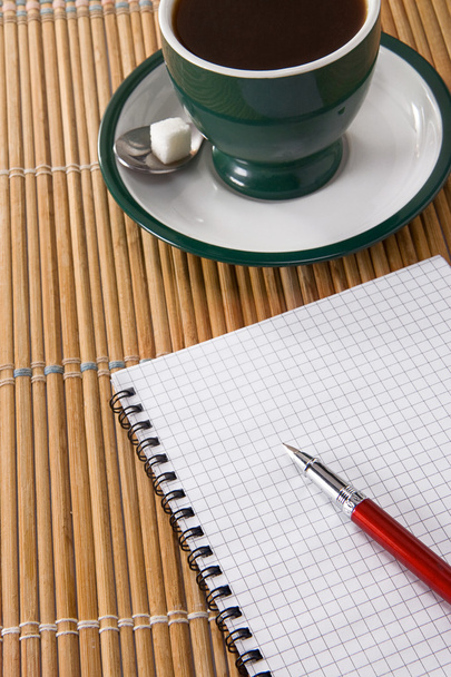 Cup of coffee and ink pen with checked notebook - Fotoğraf, Görsel