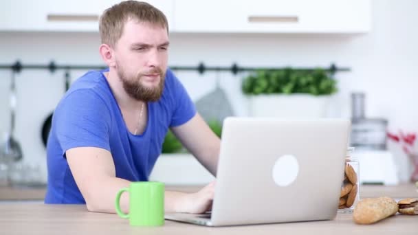 Man is werken met een laptop en eten apple - Video