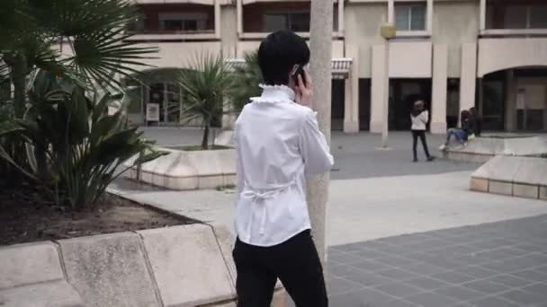 Frau, die auf der Straße läuft und mit dem Smartphone spricht. - Filmmaterial, Video