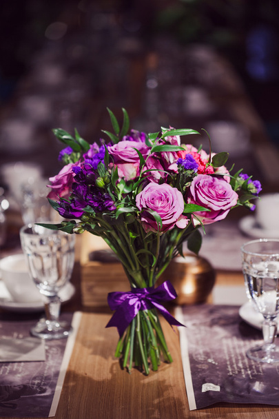 Composição de flores em restaurante, rosas e íris, tons de combinação de roxo
 - Foto, Imagem