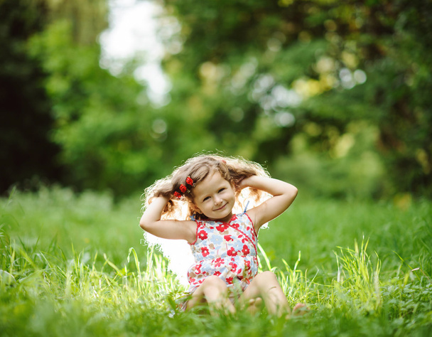 Little pretty girl in the green garden - Foto, afbeelding
