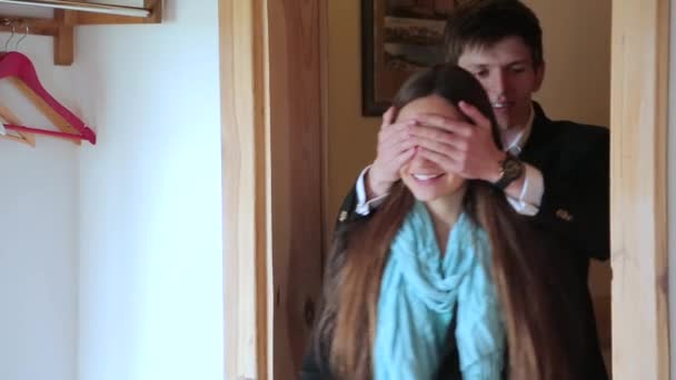 Man closes girls eyes with his hands for surprise - Materiał filmowy, wideo