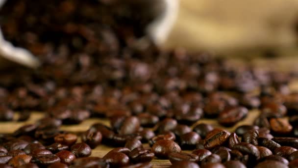 Dolly of scattered coffee beans, bag with coffee beans in the background - Séquence, vidéo