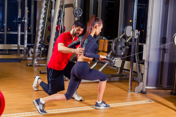 fitness, esporte, treinamento e conceito de pessoas - Personal trainer ajudando a mulher que trabalha com no ginásio
 - Foto, Imagem
