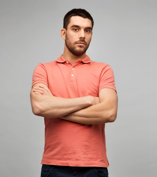 young man with crossed arms over gray background - Foto, Imagen