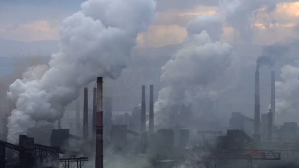 Загрязнение воздуха промышленными предприятиями. Большое растение на фоне города. Трубы, бросающие дым в небо
 - Кадры, видео