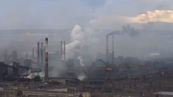 工場から大気汚染。都市の背景に大きな工場。パイプの煙を空に投げて - 映像、動画